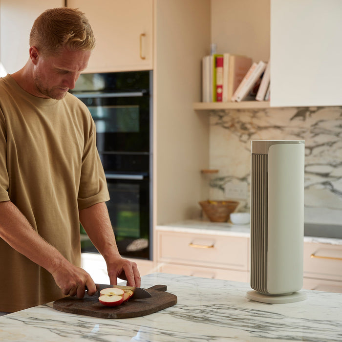 MeacoFan Sefte 19" Tower Fan on a kitchen counter while a man prepares food