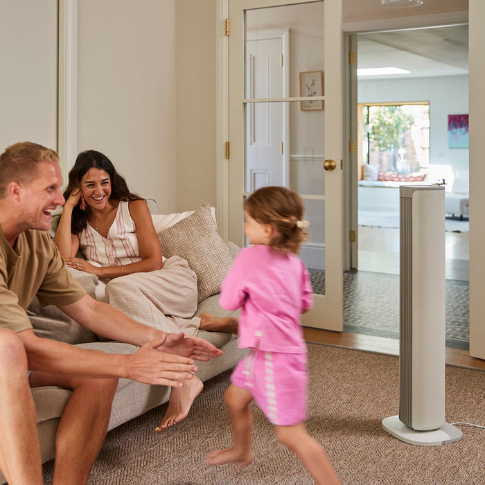 MeacoFan Sefte Smart 36" Tower Fan cooling a lounge while a family relaxes and a child runs past